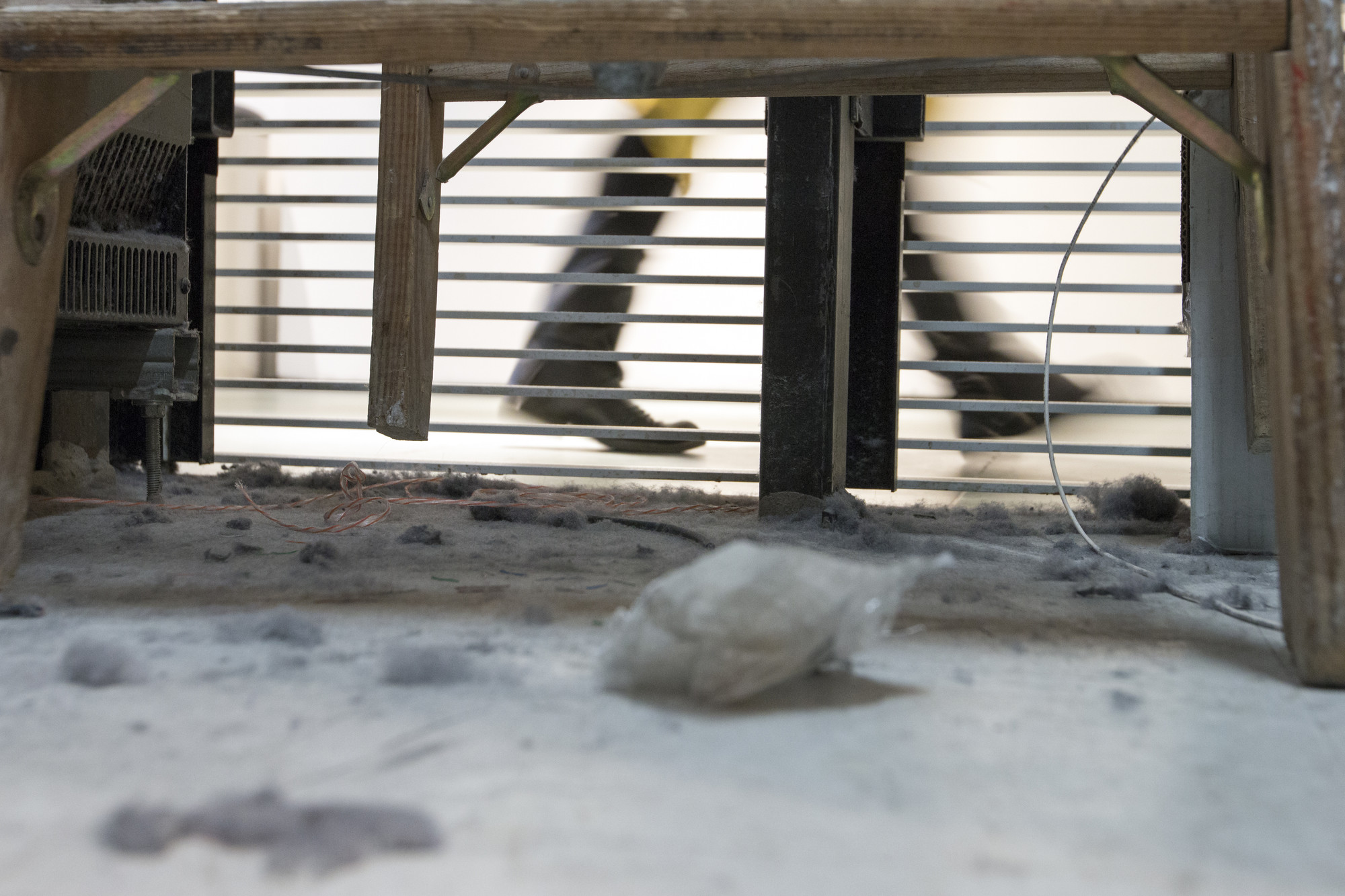 a photograph from the interior of a vent, showing a layer of thick layer of dust and debri, centered on a large tuft of dust, cropped into a circle